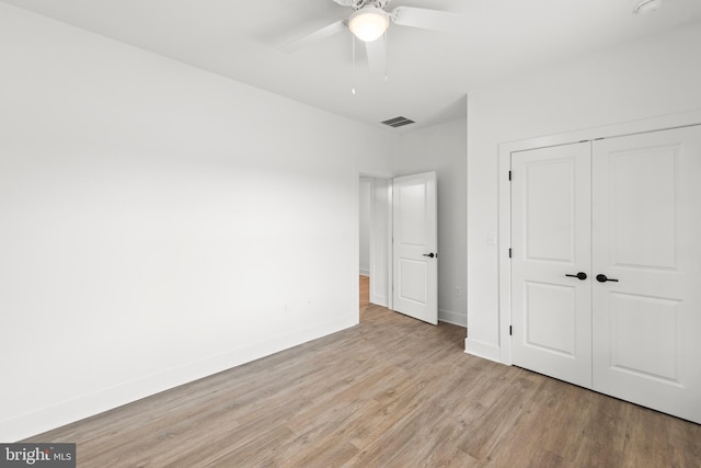 unfurnished bedroom featuring ceiling fan, a closet, and light hardwood / wood-style flooring