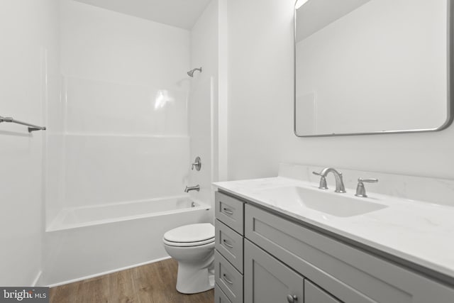 full bathroom featuring hardwood / wood-style flooring, vanity, tub / shower combination, and toilet