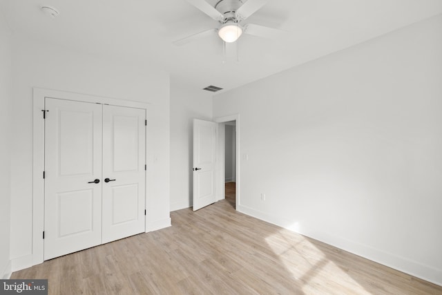 unfurnished bedroom featuring ceiling fan, light hardwood / wood-style floors, and a closet