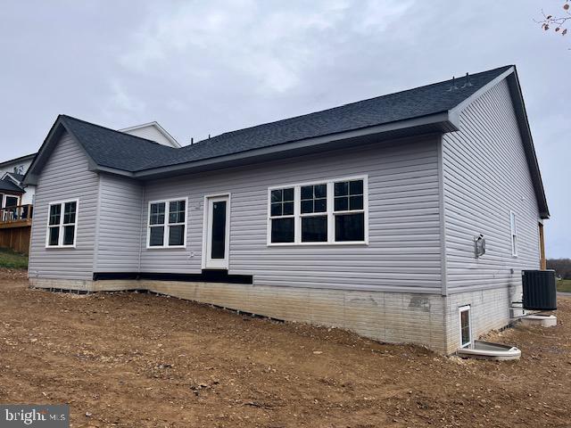 rear view of property with central AC