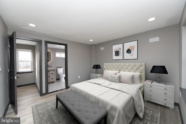 bedroom featuring ensuite bathroom and light hardwood / wood-style flooring