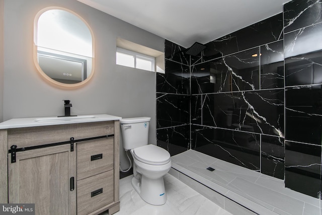 bathroom featuring tiled shower, vanity, and toilet