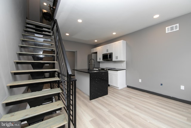 stairway featuring sink and wood-type flooring