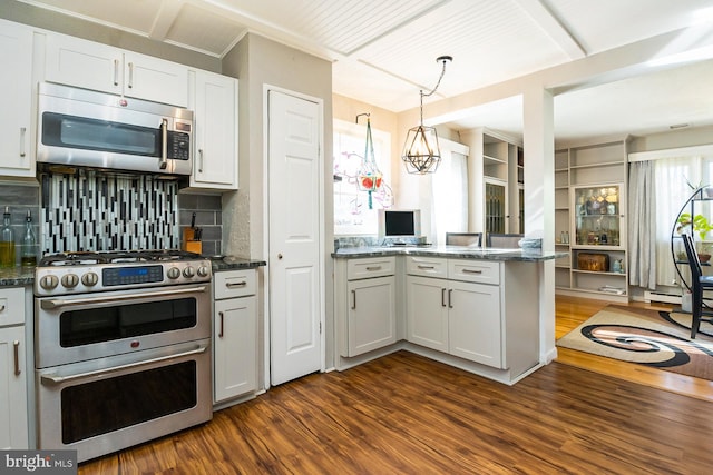 kitchen featuring white cabinets, appliances with stainless steel finishes, dark hardwood / wood-style floors, and tasteful backsplash