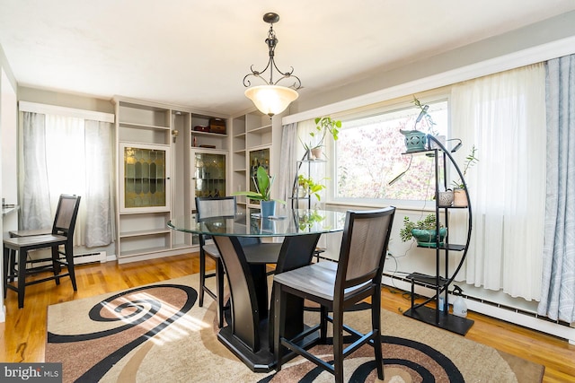 dining room with light hardwood / wood-style flooring and baseboard heating