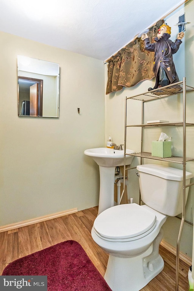 bathroom featuring wood-type flooring and toilet