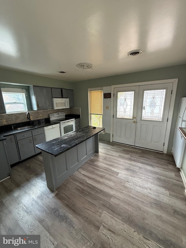 kitchen with white appliances, light hardwood / wood-style flooring, gray cabinetry, and sink