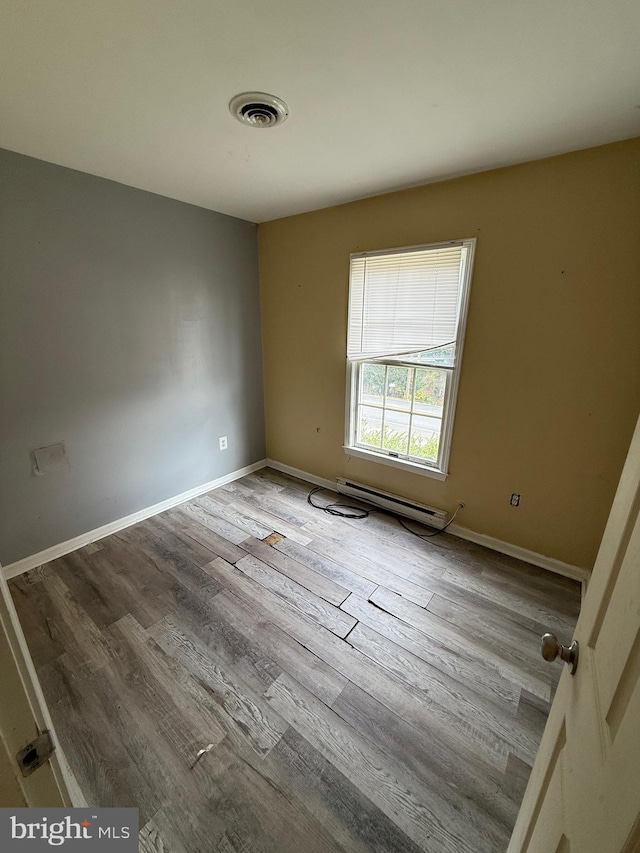 spare room featuring light hardwood / wood-style floors and a baseboard radiator