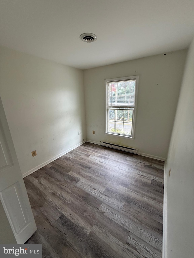 unfurnished room featuring a baseboard radiator and hardwood / wood-style flooring