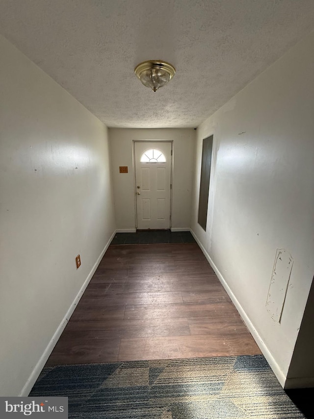 doorway to outside with dark hardwood / wood-style floors and a textured ceiling