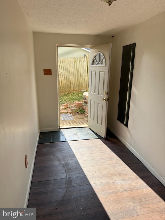 foyer entrance with hardwood / wood-style floors and a textured ceiling