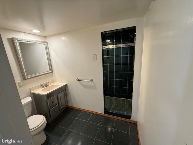 bathroom with a tile shower, tile patterned floors, vanity, and toilet