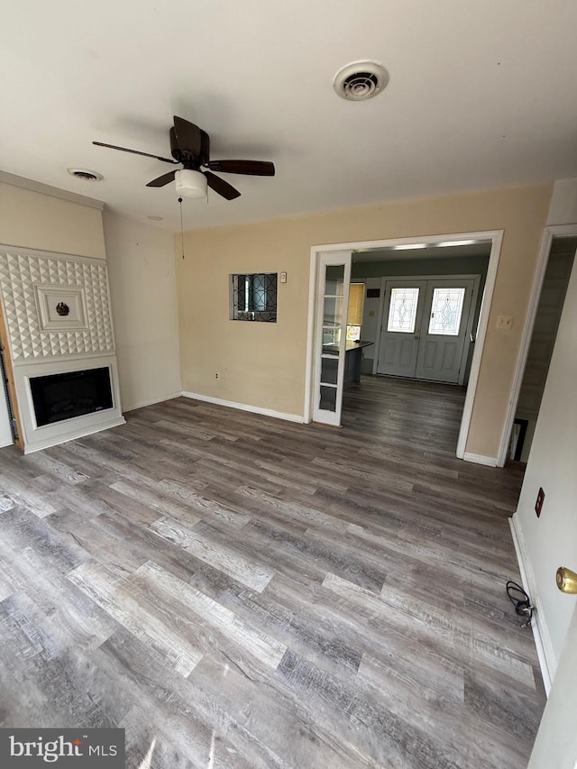 unfurnished living room featuring ceiling fan and hardwood / wood-style flooring