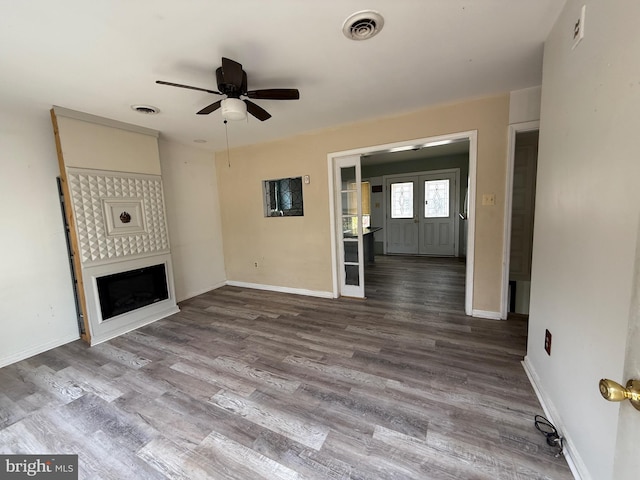 unfurnished living room with hardwood / wood-style flooring and ceiling fan