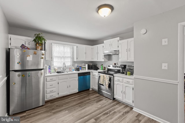 kitchen featuring white cabinets, stainless steel appliances, light hardwood / wood-style floors, and sink