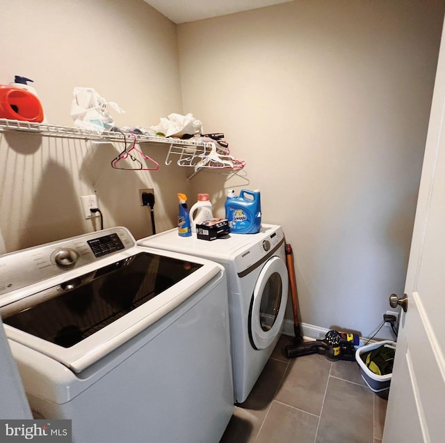 laundry room with washing machine and clothes dryer and tile patterned floors