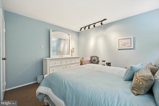 bedroom with dark colored carpet and rail lighting