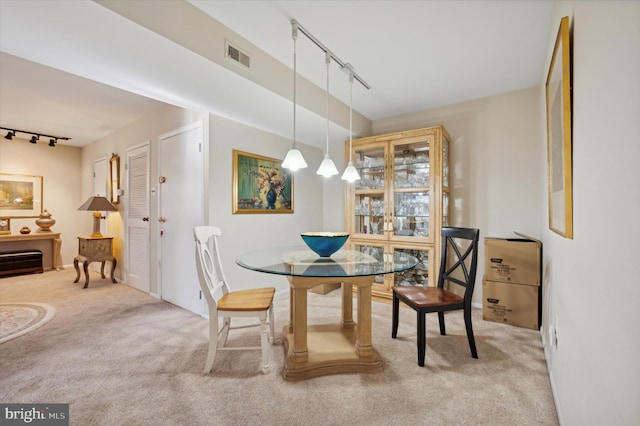 carpeted dining room with track lighting