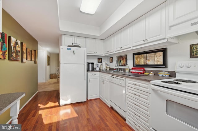 kitchen featuring white cabinets, sink, white appliances, and hardwood / wood-style floors