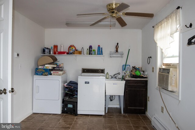 laundry area with sink, washer and dryer, ceiling fan, dark tile patterned floors, and baseboard heating