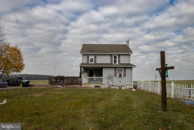 rear view of house with a porch and a yard