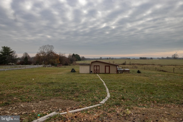 view of yard with a rural view and an outdoor structure