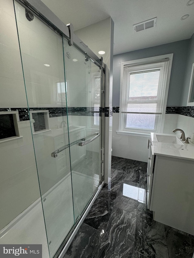 bathroom with vanity and a shower with shower door