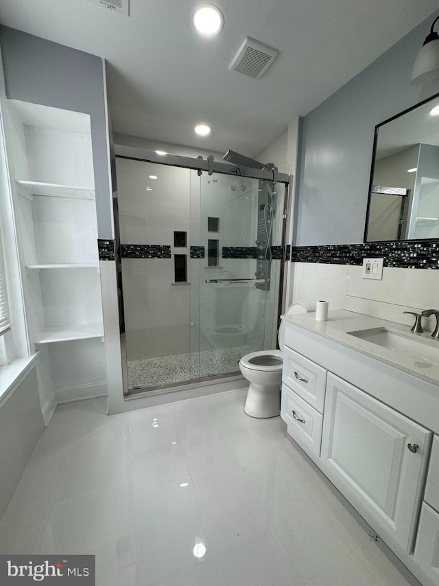 bathroom featuring tile patterned floors, toilet, and a shower with door