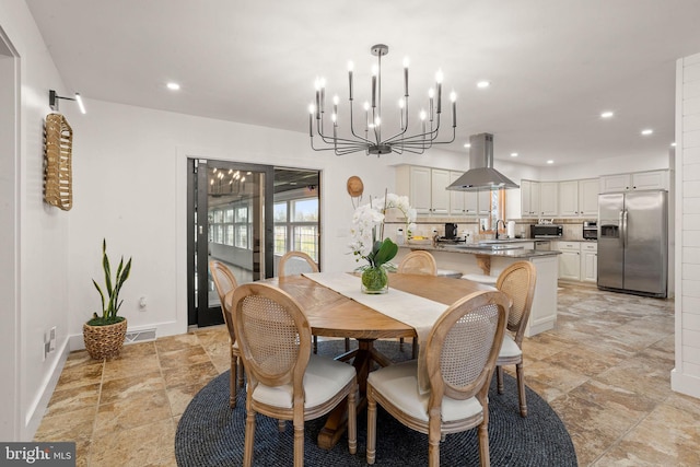 dining area with sink and an inviting chandelier