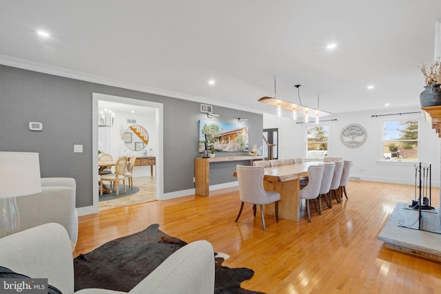 dining room featuring light hardwood / wood-style flooring and ornamental molding