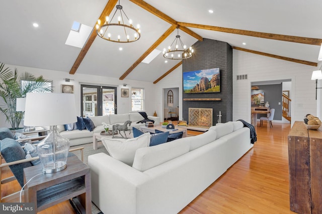 living room with high vaulted ceiling, an inviting chandelier, a fireplace, beam ceiling, and light hardwood / wood-style floors