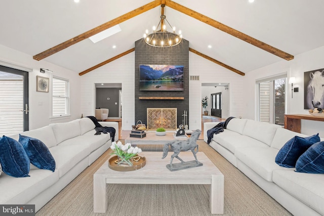 living room with a skylight, a fireplace, high vaulted ceiling, an inviting chandelier, and beamed ceiling