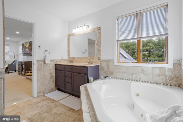 bathroom featuring tile patterned floors, tiled bath, and vanity