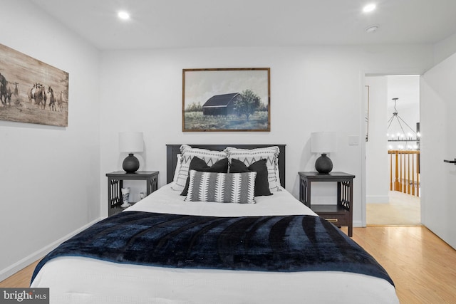 bedroom featuring wood-type flooring and a notable chandelier