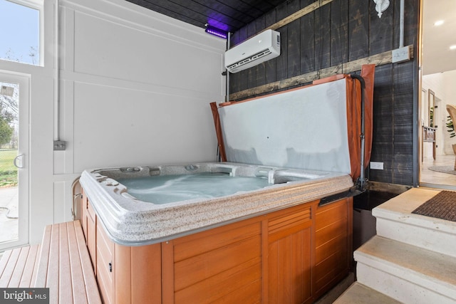 interior space with a wall unit AC and a hot tub