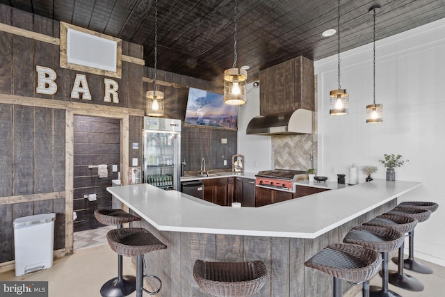 kitchen featuring a breakfast bar, sink, black dishwasher, decorative light fixtures, and stainless steel gas cooktop