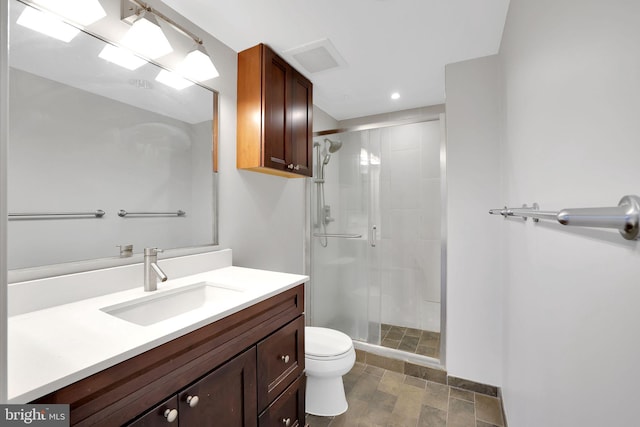 bathroom with walk in shower, vanity, and toilet