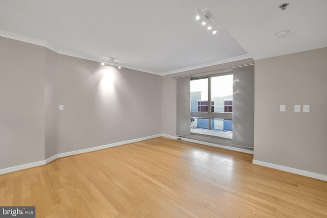 spare room with track lighting, light hardwood / wood-style flooring, and crown molding