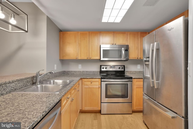 kitchen featuring light brown cabinetry, stainless steel appliances, light hardwood / wood-style floors, and sink