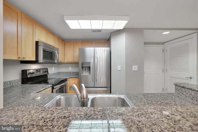 kitchen with light brown cabinetry, sink, and appliances with stainless steel finishes