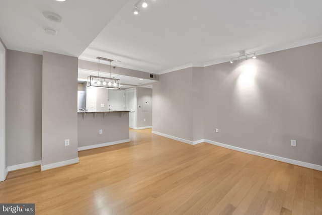 unfurnished living room with rail lighting, light hardwood / wood-style floors, and ornamental molding