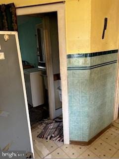 bathroom with washer and dryer and tile patterned flooring