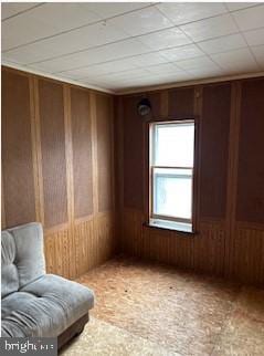 unfurnished room featuring wooden walls