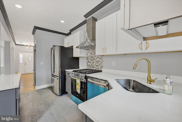 kitchen with white cabinetry, stainless steel appliances, wall chimney range hood, crown molding, and sink