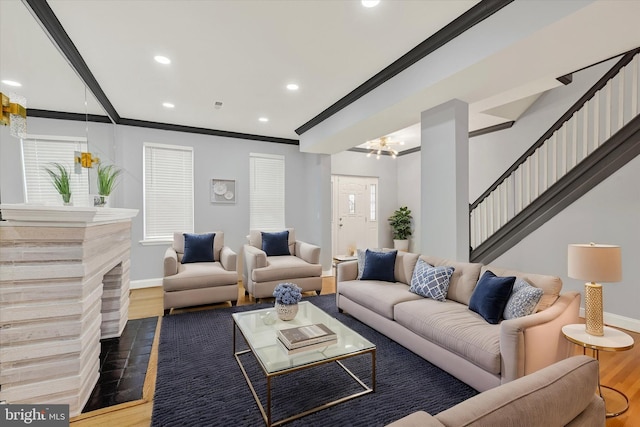 living room with dark wood-type flooring, ornamental molding, and a notable chandelier