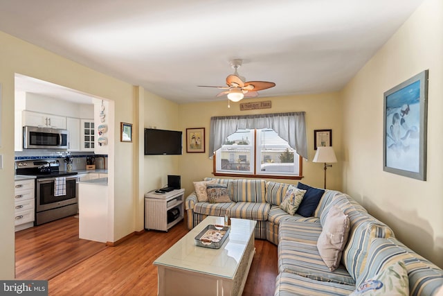 living room featuring hardwood / wood-style floors and ceiling fan