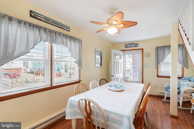 dining space with plenty of natural light, a baseboard radiator, and hardwood / wood-style flooring