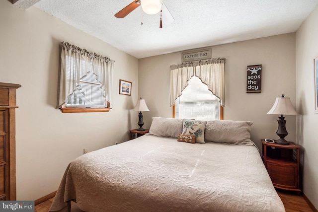 bedroom featuring hardwood / wood-style floors, a textured ceiling, and ceiling fan