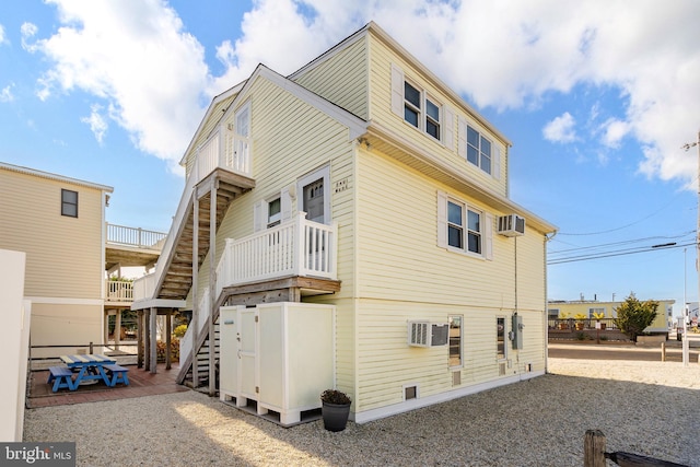 view of side of home featuring a patio and a wall mounted AC