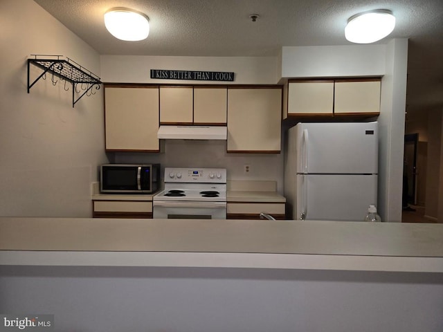 kitchen featuring a textured ceiling and white appliances